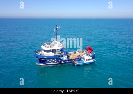 Bateau de pêche en mer avec un plus petit bateau amarré à côté - Vue aérienne de l'image. Banque D'Images