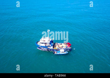 Bateau de pêche en mer avec un plus petit bateau amarré à côté - Vue aérienne de l'image. Banque D'Images