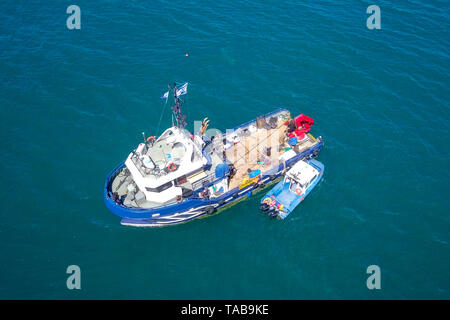 Bateau de pêche en mer avec un plus petit bateau amarré à côté - Vue aérienne de l'image. Banque D'Images