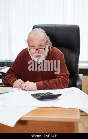 Portrait of senior man barbu blanc chemise habillée à la table dans la salle de bureau. Travailler avec les bleus, une personne Banque D'Images