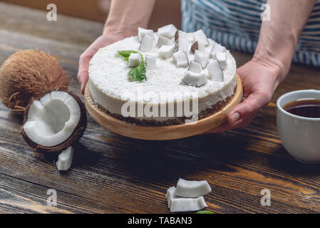 La noix de coco gâteau pâtissier décore brut avec de la pâte blanche et la menthe sur fond de bois. L'été frais et sain dessert vegan. L'alimentation sans gluten et sans sucre Banque D'Images