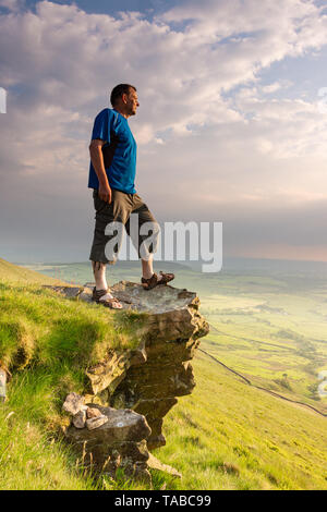 Homme debout sur un promontoire rocheux appelé 'Nick's Chair' dans la forêt de Bowland, Lancashire, UK Banque D'Images