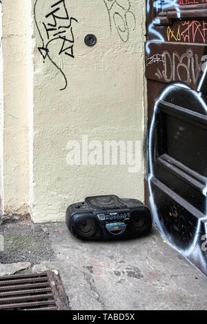 Vieille technologie - abandonnés, sous-évaluées, saccagé. Radio et lecteur de CD redondants d'un dumping sur un trottoir de la ville. Banque D'Images