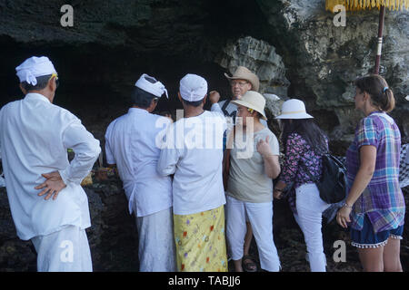 Pura Batu Bolong. Nusa Tenggara. Tabanan Pura Tanah Lot. Hindu temple construit sur un îlot. Un touriste, c'est béni par un prêtre hindou, l'Indonésie. Bali, 07,0 Banque D'Images