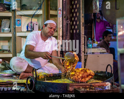 Mumbai, Inde - 11 mai 2019 : les fournisseurs Musulmans mâles vente cuisson des aliments halal et des collations fried pancake Malpuas route de caler au marché nocturne dans Banque D'Images