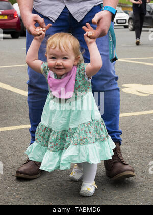 Petite fille d'un an l'apprentissage de la marche avec l'aide de son père, UK Banque D'Images