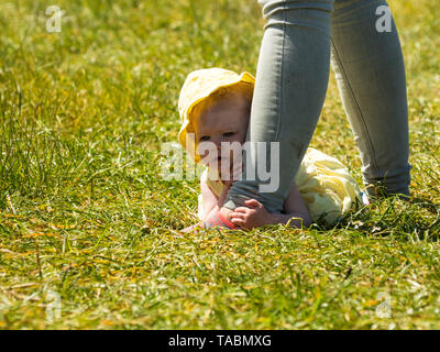 Petite fille se cacher derrière maman. Banque D'Images