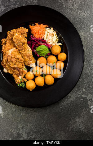 Poulet frit avec des boules de pommes de terre et salade, restaurant servant une partie. Banque D'Images