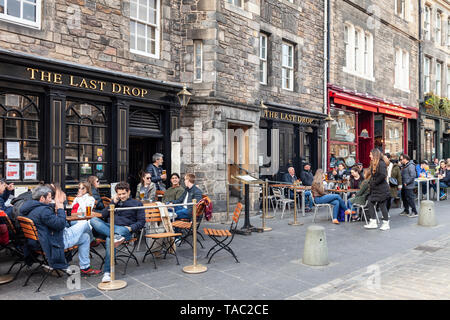 Les clients se détendre dans la utdoor assis dehors la dernière goutte pub dans le Grassmarket de la vieille ville d'Édimbourg, Écosse, Royaume-Uni Banque D'Images