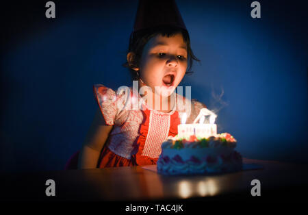 Enfants Asie blowing out candles on cake / Portrait of little pretty Girl Happy Birthday Party at night Banque D'Images