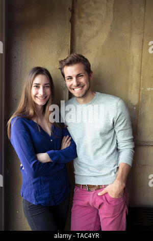 Portrait of happy young couple debout à un mur Banque D'Images