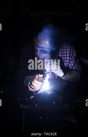 L'homme dans son atelier de soudure Banque D'Images