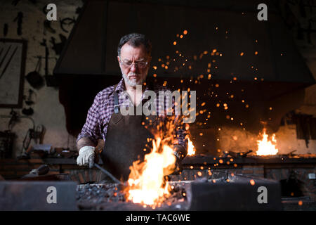 Travailler chez le forgeron forge dans son atelier Banque D'Images