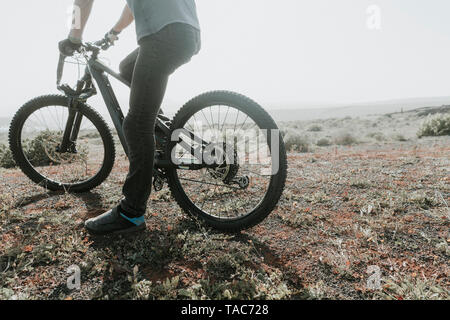 L'Espagne, Lanzarote, low section de mountainbiker lors d'un voyage dans un paysage désertique Banque D'Images