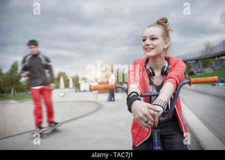 Adolescente avec vélo BMX à un skatepark Banque D'Images