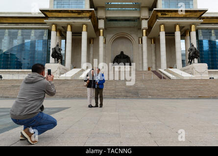 Palais du gouvernement sur la place Sükhbaatar, Ulaanbaatar, Mongolie. Couple photographié par un ami. Banque D'Images