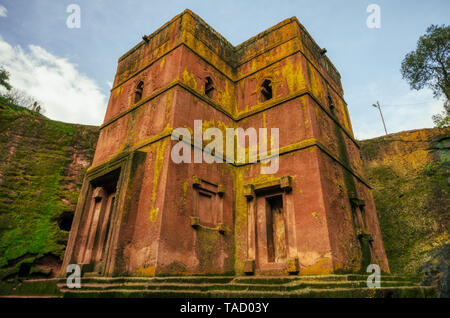 Les églises de Lalibela creusées dans la roche excavée avec la croix de San Jorge. L'incident reflète la lumière ocre, jaune et vert de chara Banque D'Images