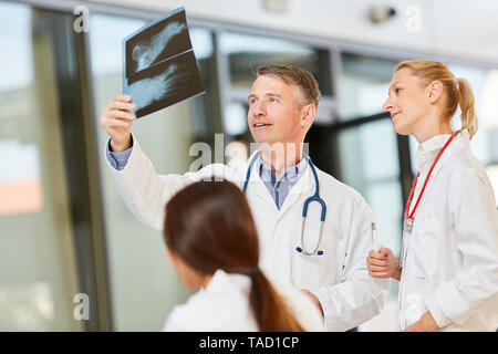 Médecin principal et l'équipe de radiologie de discuter d'une radiographie à un atelier Banque D'Images