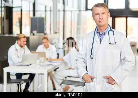 Médecin Le médecin-chef avec autorité et compétence en toute confiance est en face de son équipe Banque D'Images