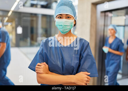 Chirurgien avec les bras croisés en face de la salle d'urgence ou en face de l'unité des soins intensifs Banque D'Images