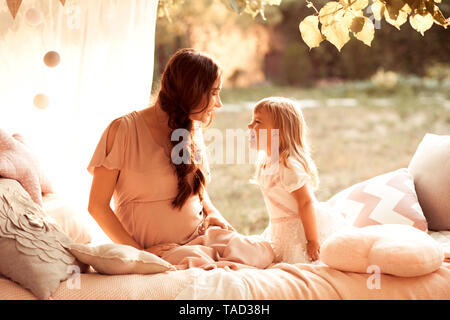 Mère d'avoir du plaisir avec kid fille dans le lit libre. À la recherche à l'autre. La maternité. Bonjour. Banque D'Images