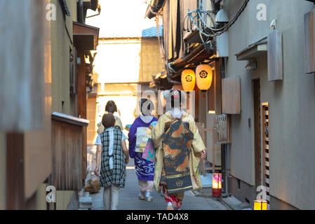 Un groupe de geisha et maiko portant un costume traditionnel (kimono) marcher sur la rue à Kyoto, au Japon. Geisha sont japonais traditionnel des femmes artistes. Banque D'Images