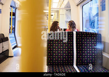 UK, Londres, deux femmes parlant dans le métro. Banque D'Images