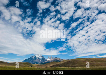 Le Chili, la Patagonie, le Parc National Torres del Paine, prairie et montagne sous ciel nuageux Banque D'Images