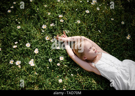 Petite fille se trouvant dans le champ de fleurs Banque D'Images