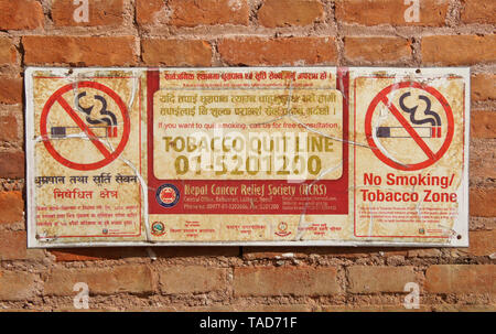 Le bilinguisme (anglais et Népalais) 'non fumeurs' signer sur mur de brique dans Bhaktapur, Vallée de Katmandou, Népal Banque D'Images