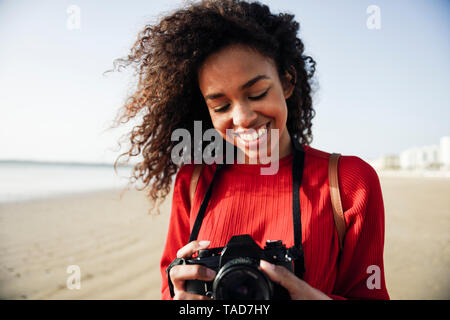 Smiling young woman looking at camera sur la plage Banque D'Images