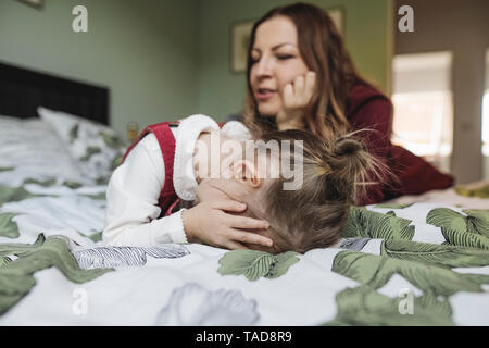 Mère et sad girl lying on bed Banque D'Images