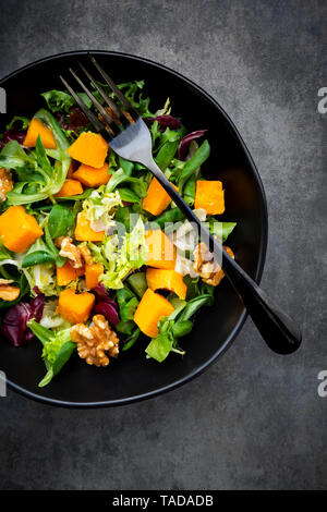 Bol de salade verte avec des noix et de potiron Hokkaido Banque D'Images