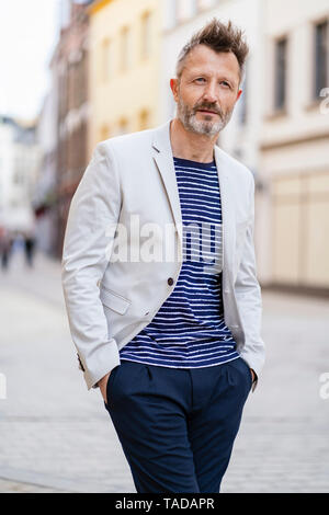 Portrait d'homme mûr avec barbe grisonnante marcher dans la ville Banque D'Images