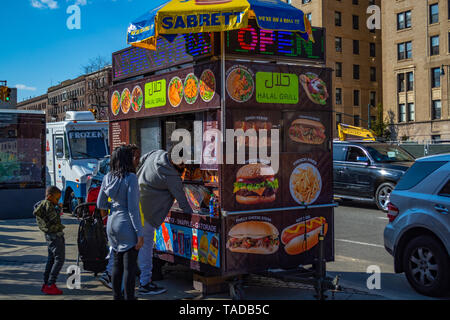 Un homme est l'achat d'aliments dans la rue à l'alimentation halal. Banque D'Images