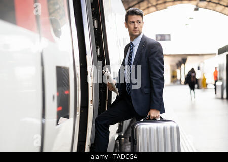 Businessman with suitcase obtenir en train Banque D'Images