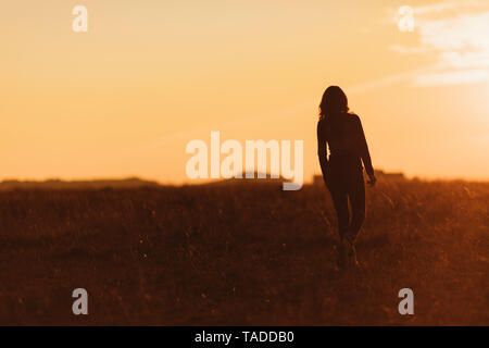 Femme marche dans la nature au coucher du soleil Banque D'Images