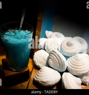 Verre de gel bleu et un tas de morceaux de savon artisanal naturel Banque D'Images