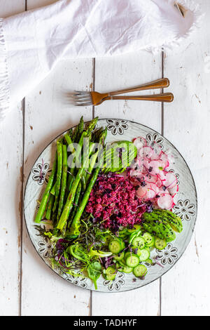 Assiette de salade printanière aux asperges vertes, quinoa rouge, avocat, concombre, radis rouge et pousses Banque D'Images