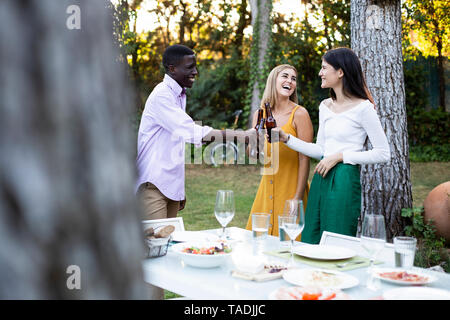 Freinds with beer à un dîner d'été dans le jardin Banque D'Images