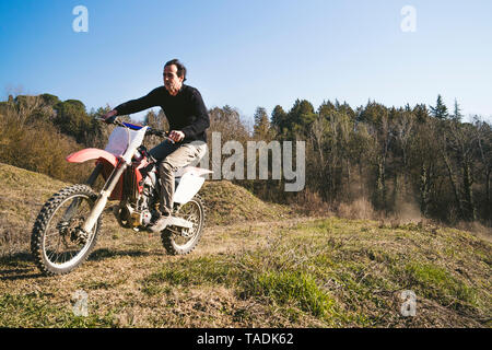 Pilote de motocross Senior équitation sur le circuit Banque D'Images