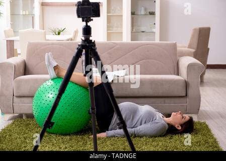Femme enceinte blogger faisant des exercices physiques Banque D'Images