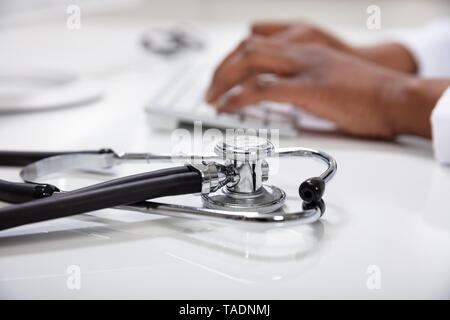 Close-up de médecin de taper au clavier avec stéthoscope Banque D'Images