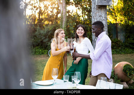 Freinds with beer à un dîner d'été dans le jardin Banque D'Images