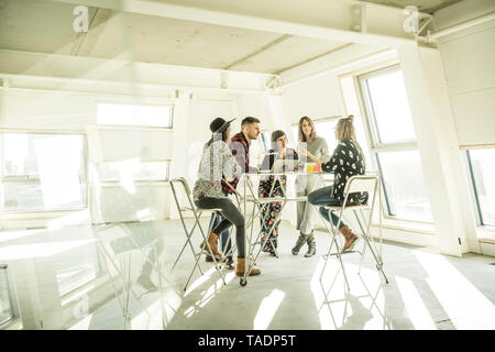 Groupe de professionnels de la création d'une réunion dans un bureau lumineux, de discuter de nouvelles solutions Banque D'Images