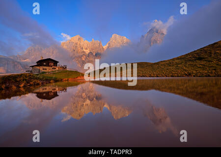 L'Italie, le groupe de montagne avec la montagne Pale di San Martino avec Cimon della Pala se reflétant dans petit lac au coucher du soleil, le Rifugio Baita Giovanni Segantini Banque D'Images