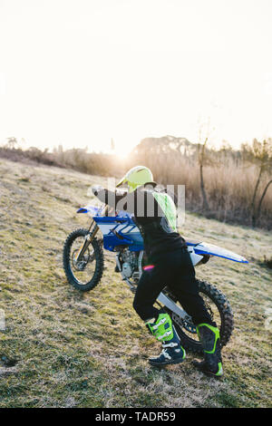 En poussant sa moto Motocross sur le circuit Banque D'Images