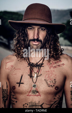 Jeune homme avec chapeau, moustache et des tatouages Banque D'Images