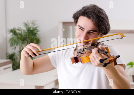 Jeune musicien man à jouer du violon à la maison Banque D'Images