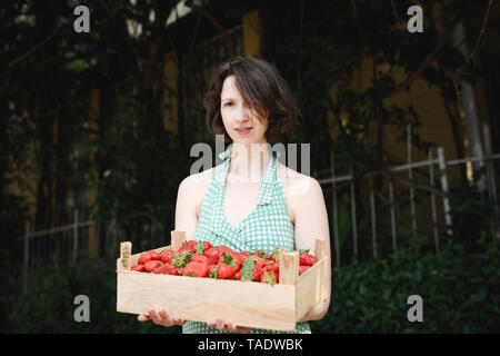 Portrait of woman holding caisse avec des fraises Banque D'Images